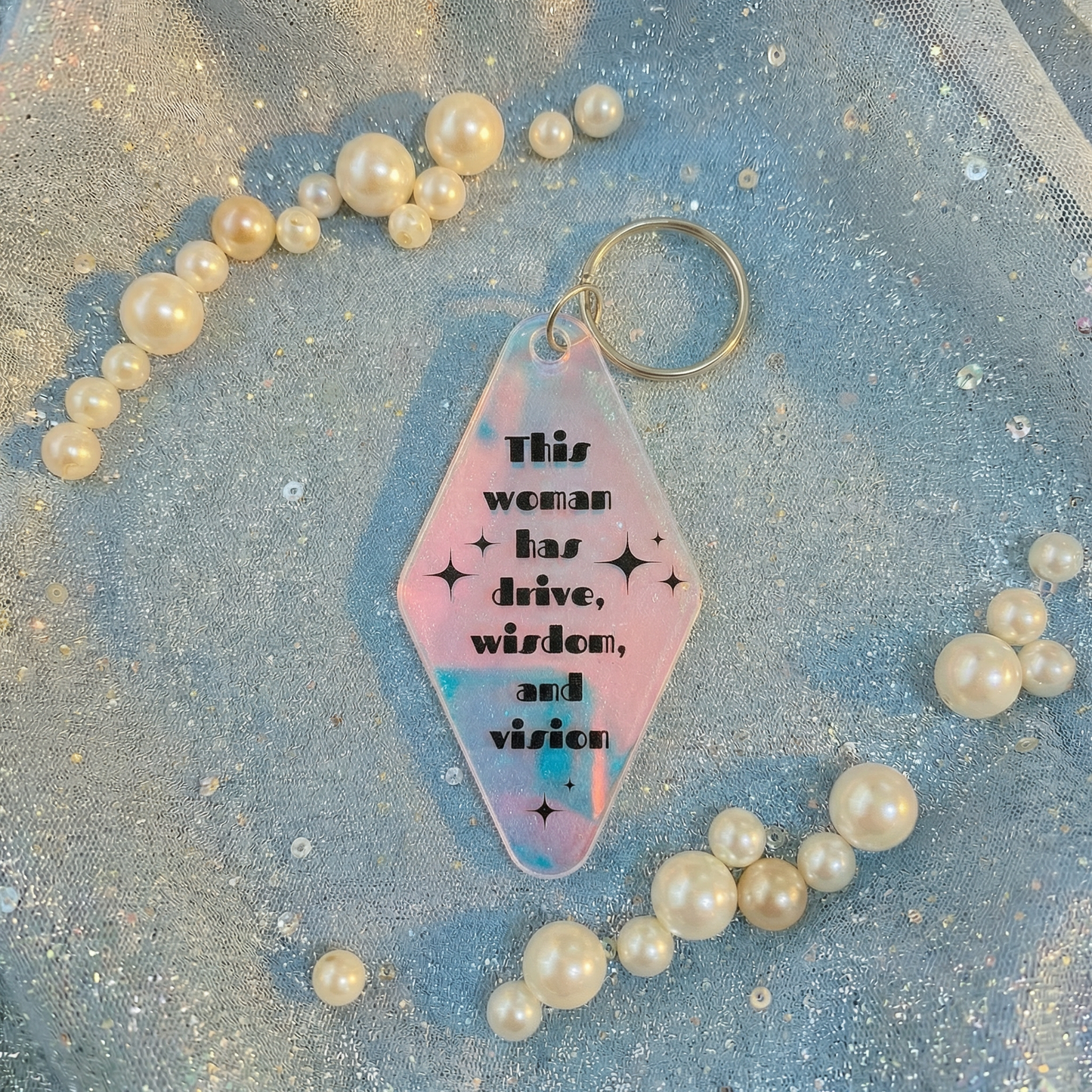 Keychain with motivational quote surrounded by pearls on a glittery background