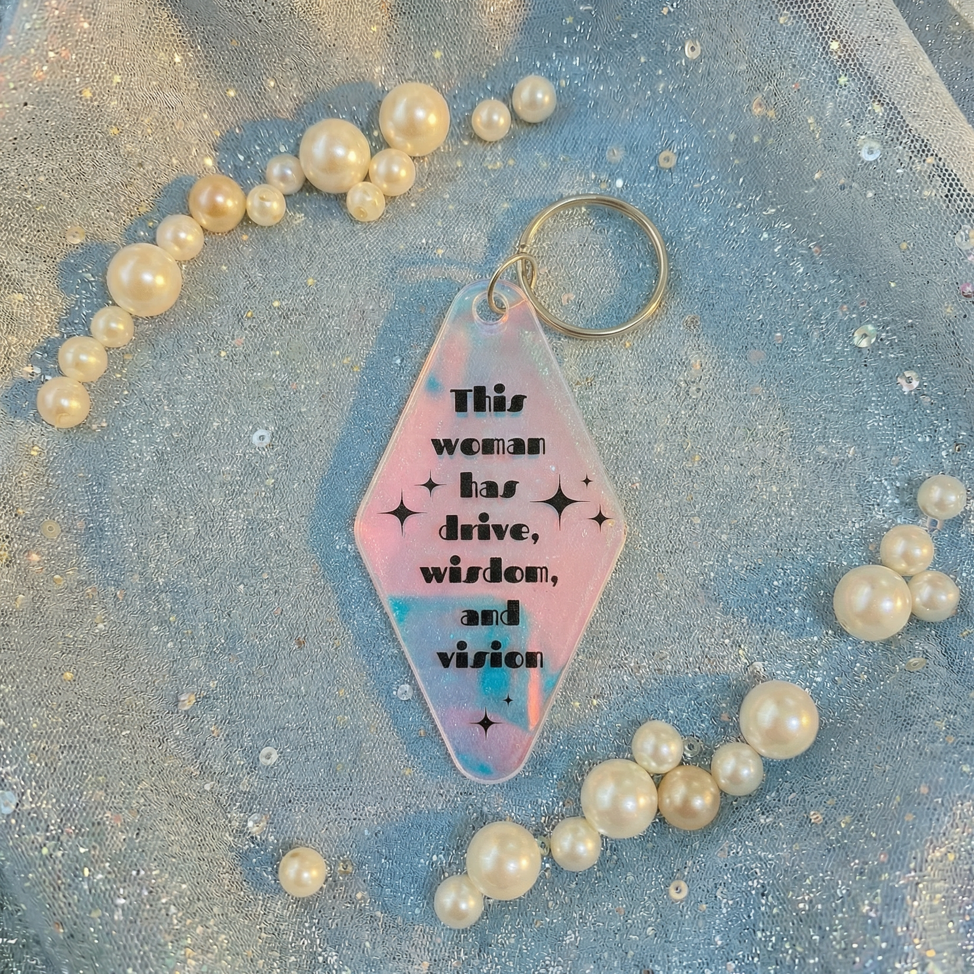 Keychain with motivational quote surrounded by pearls on a glittery background