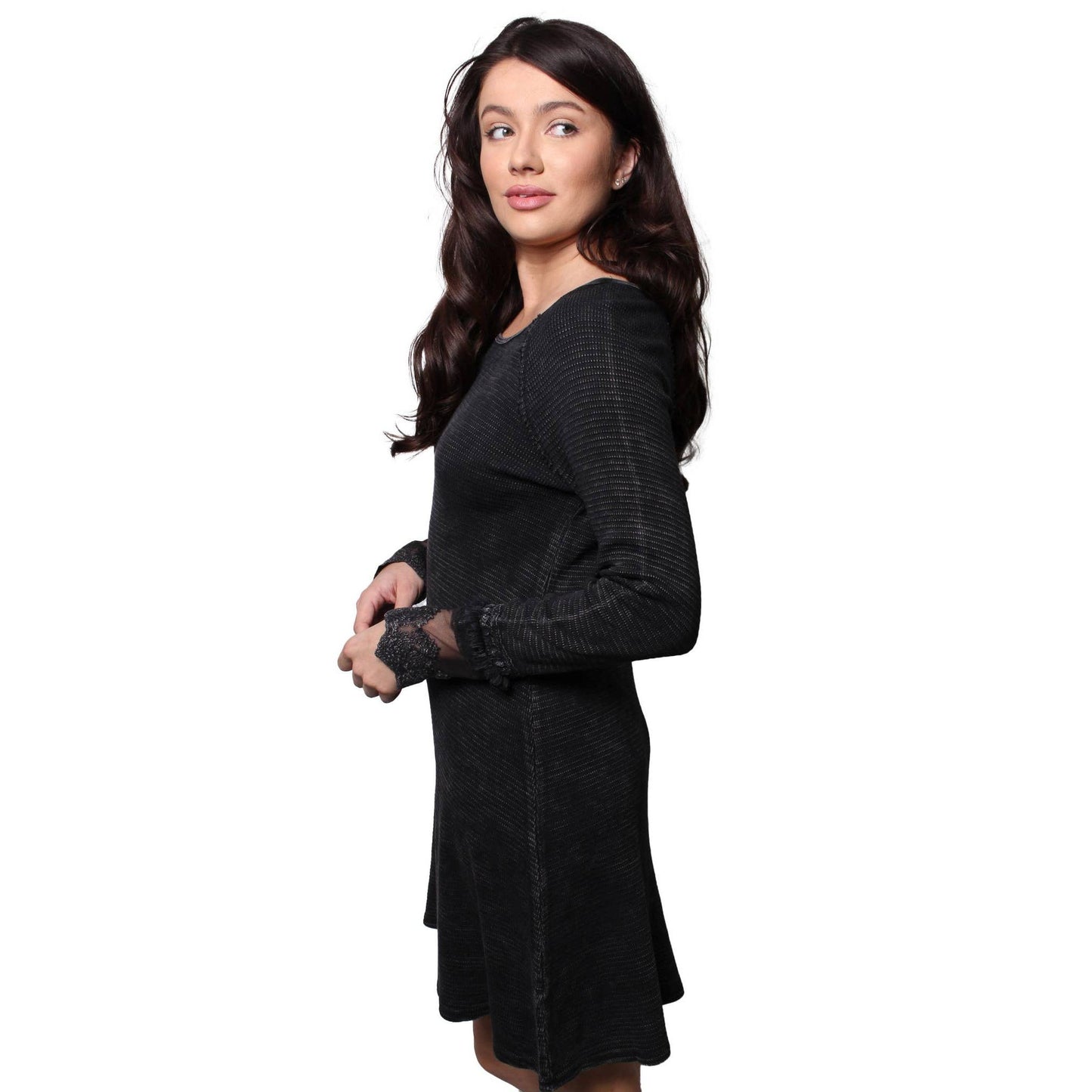 Woman wearing a black long sleeved waffle dress with lace detail at sleeves on a white background