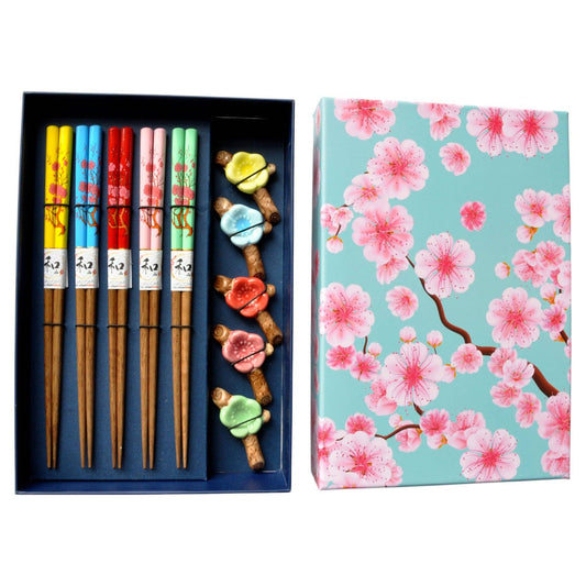 A boxed set of five wooden chopsticks with colorful floral handles and small decorative chopsticks rest, with matching gift box printed with pink cherry blossoms