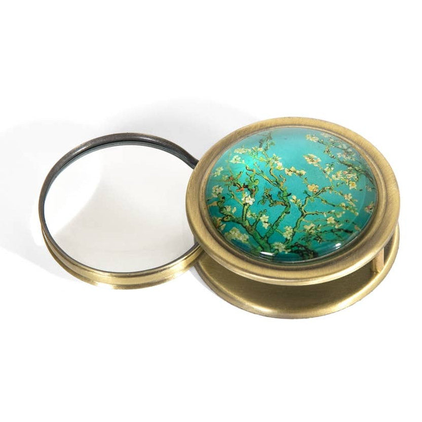 Compact magnifying glass with floral design on a white background