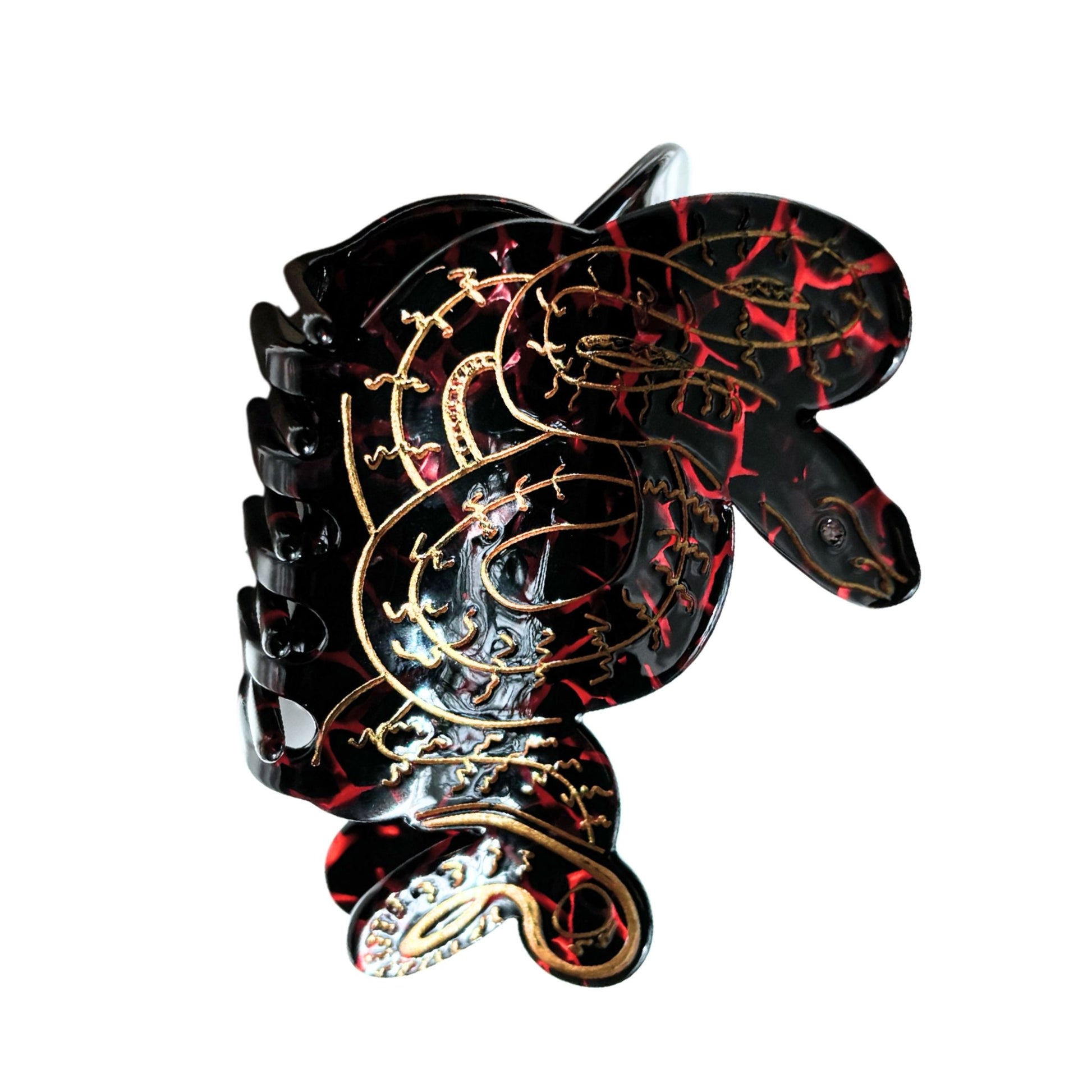 Snake shaped hair claw with black, red, and gold design on a white background