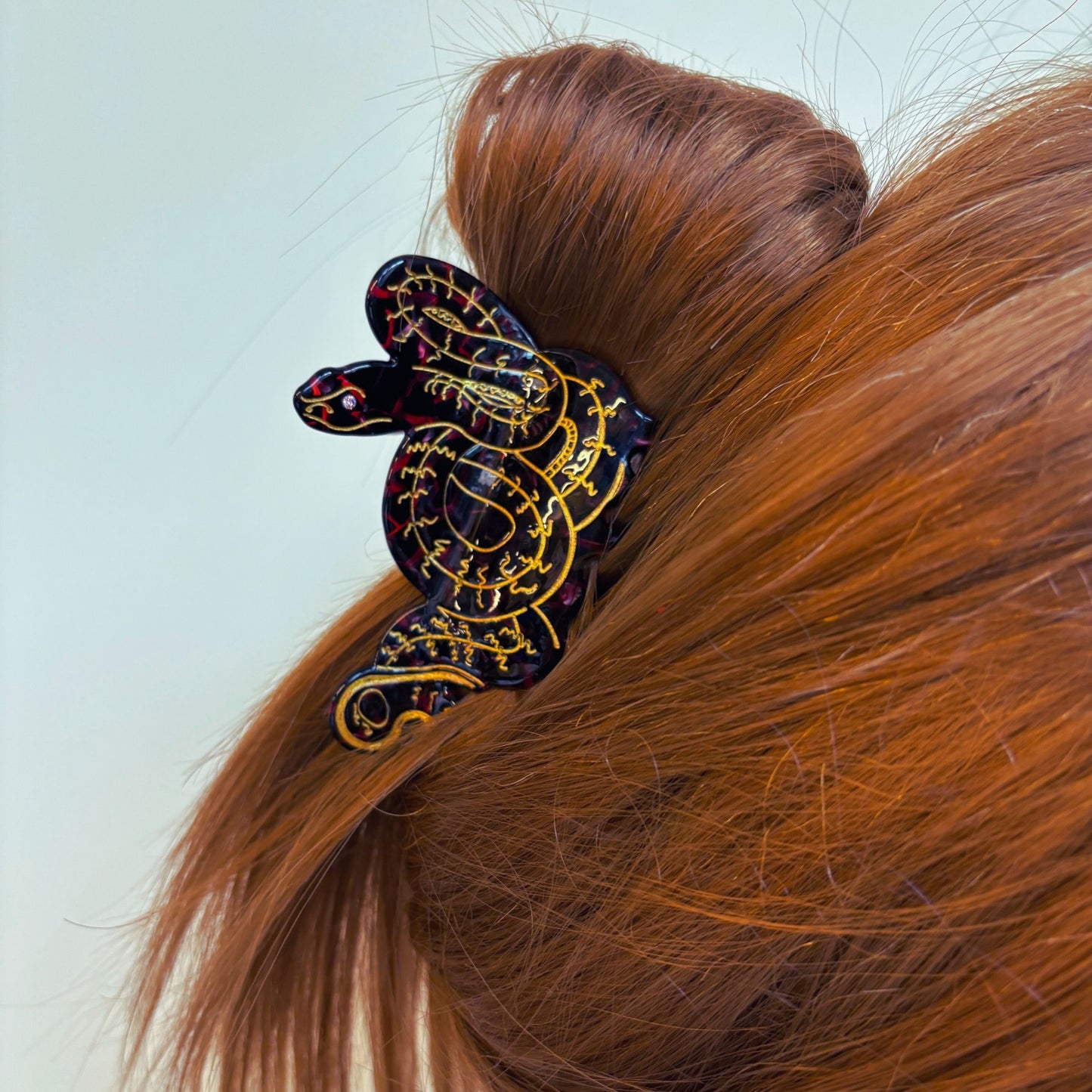 Decorative hair clip on a person's hair against a light blue background