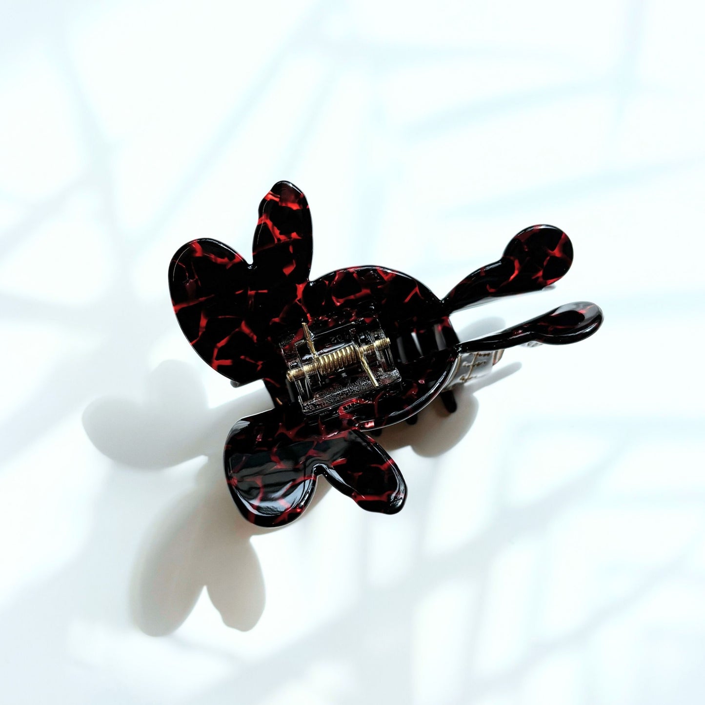 Black and red marbled hair clip on a white background