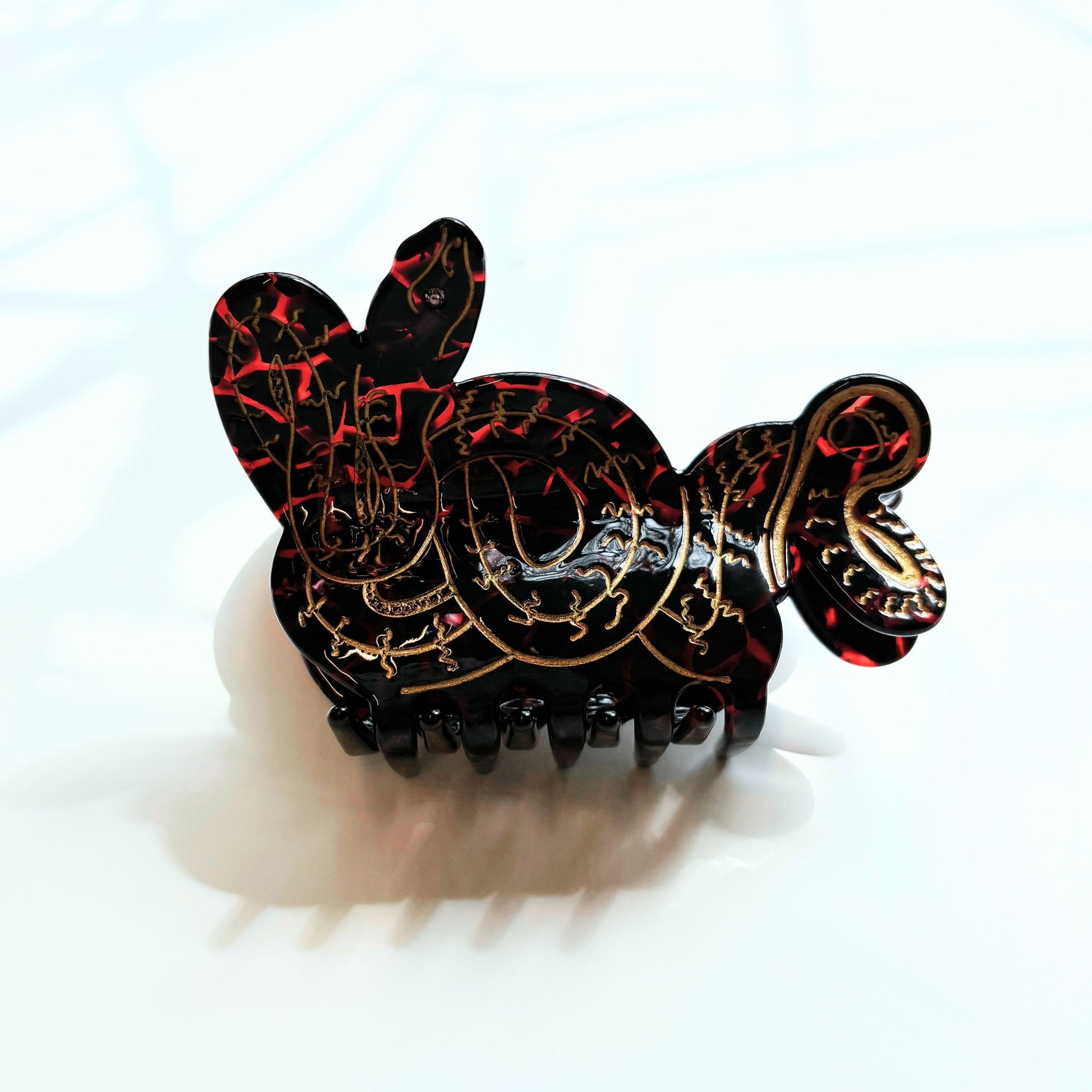 Decorative hair clip with intricate designs on a white background