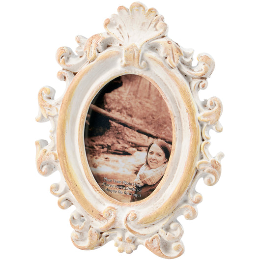 Decorative oval picture frame with intricate designs on a white background