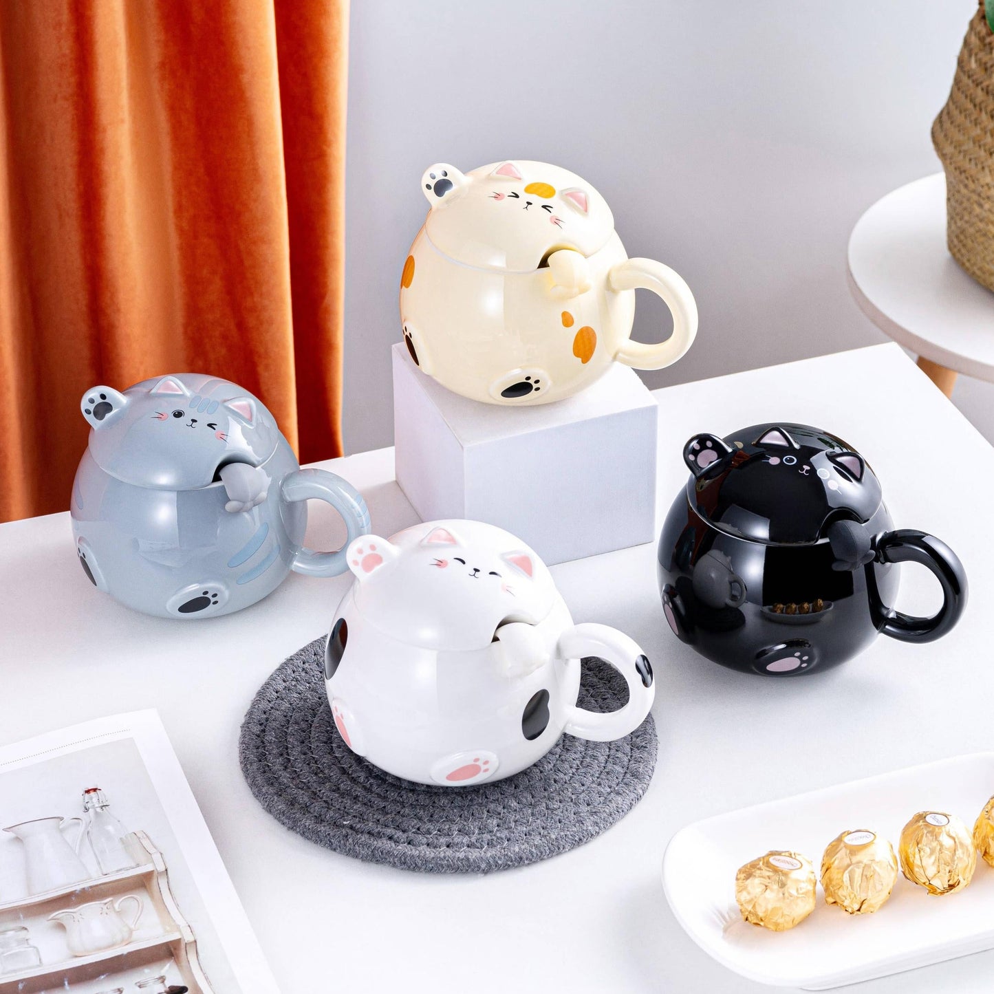 Set of cartoon-themed mugs and teapot on a table with decorative items.