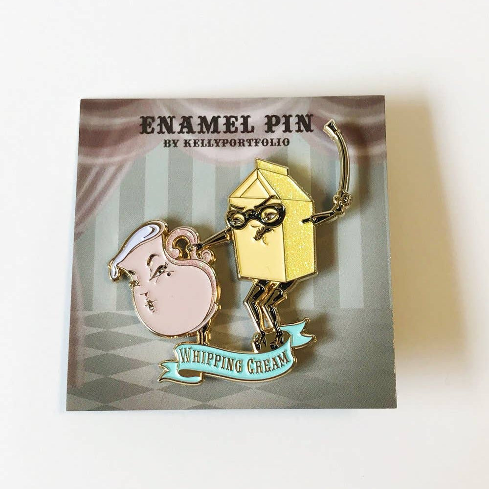 Whipping cream enamel pin packaging with two characters, a box and a pink cup