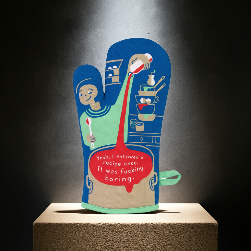 Oven mitt with cartoon design and humorous text on a dark background