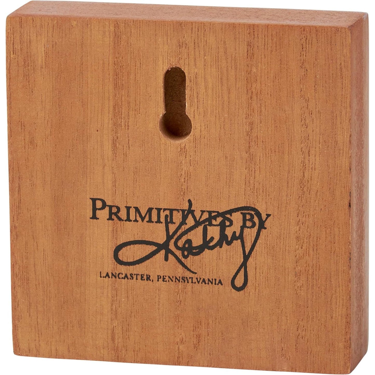 Wooden block with 'Primitives by Kathy' logo and text 