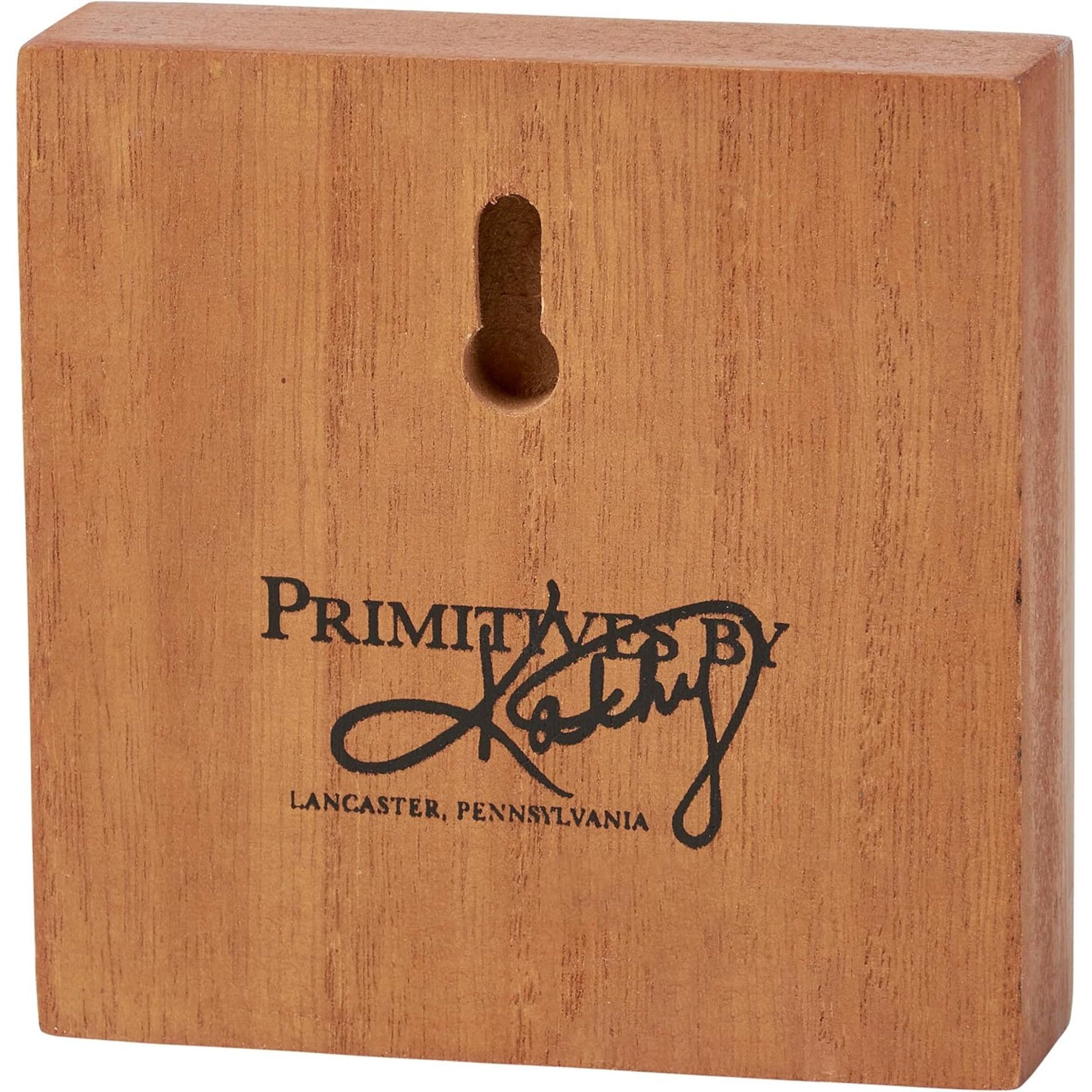 Wooden block with 'Primitives by Kathy' logo and text 