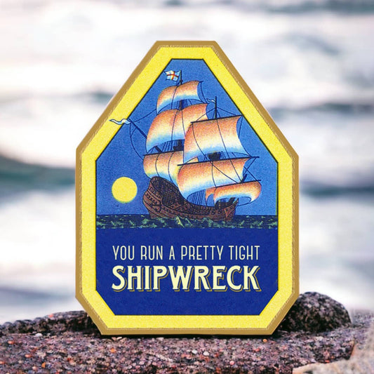 Decorative sign with a shipwreck design and text on a beach background