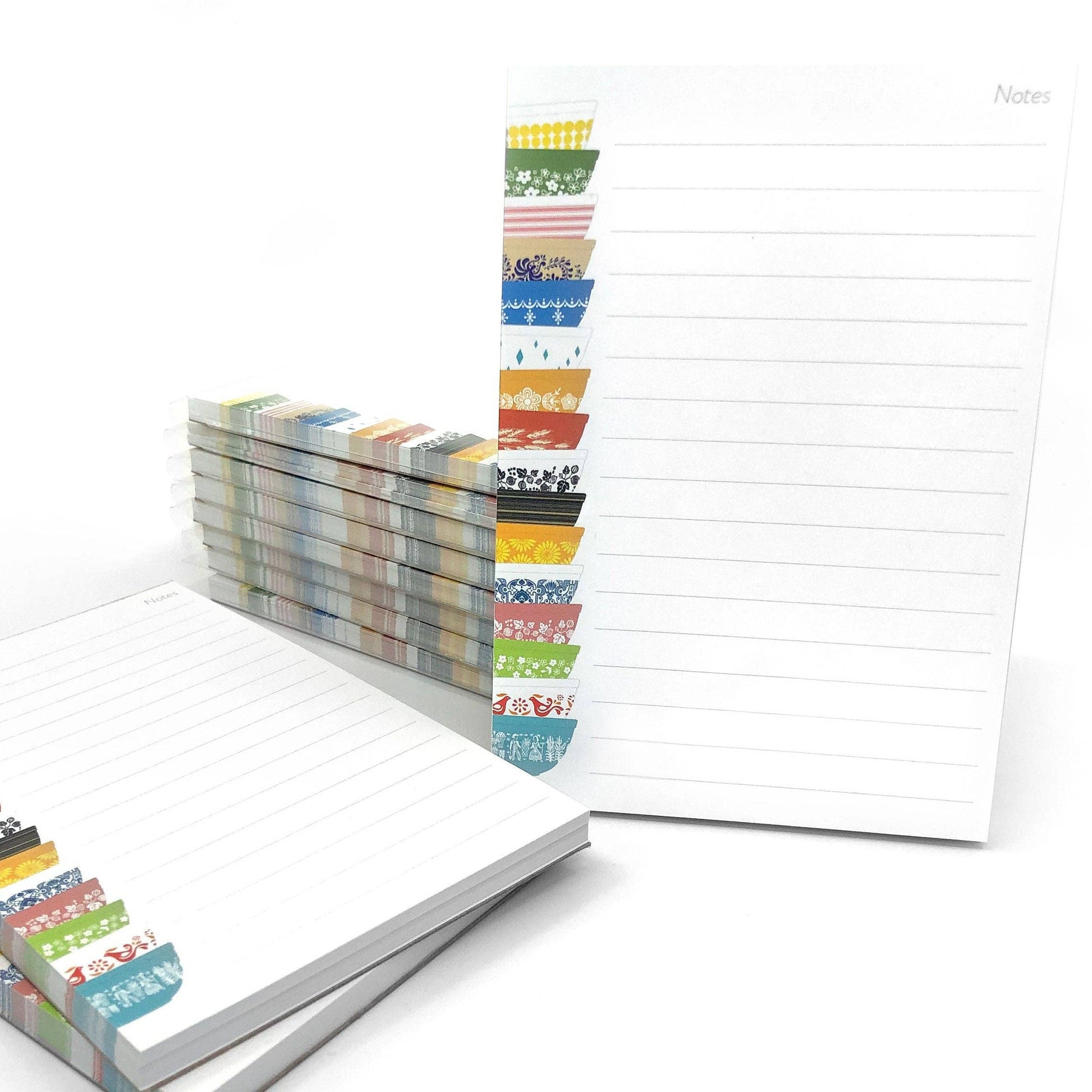 Stacks of colorful notepad with lined paper on a white background