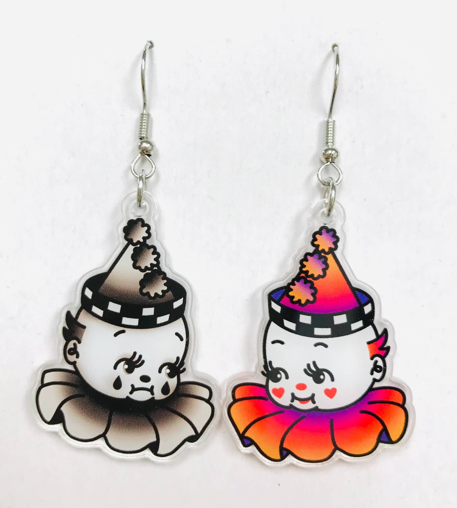 Mismatched pair of earrings with clown character designs - one is a happy clown and another is a sad clown